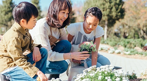 綺麗なお花を持っている女性の隣に男女の子供がいる